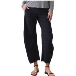 black loose pants worn by woman with hand in pocket and grey tshirt on