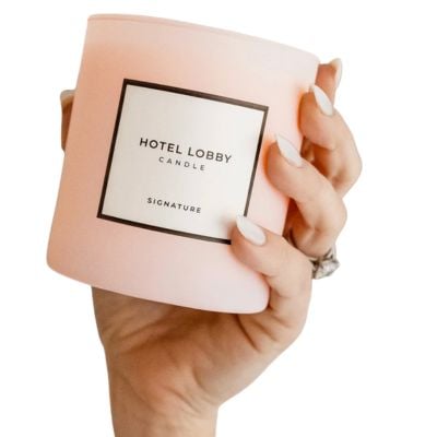 womans hand holding up a candle